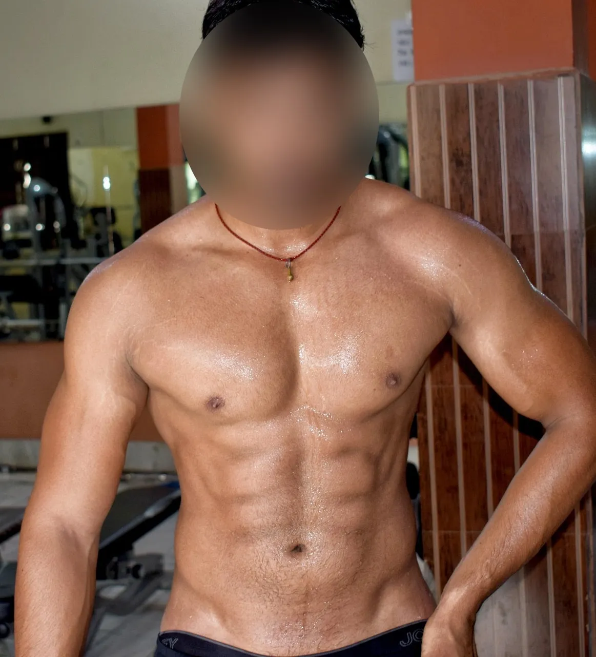 Léandre, torse en salle de musculation, visage flouté